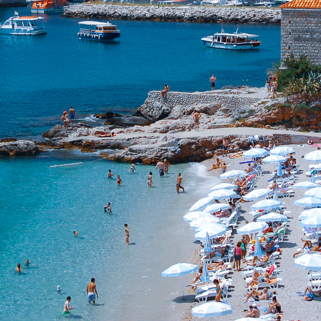 Beach with people and umberalls in Croatia