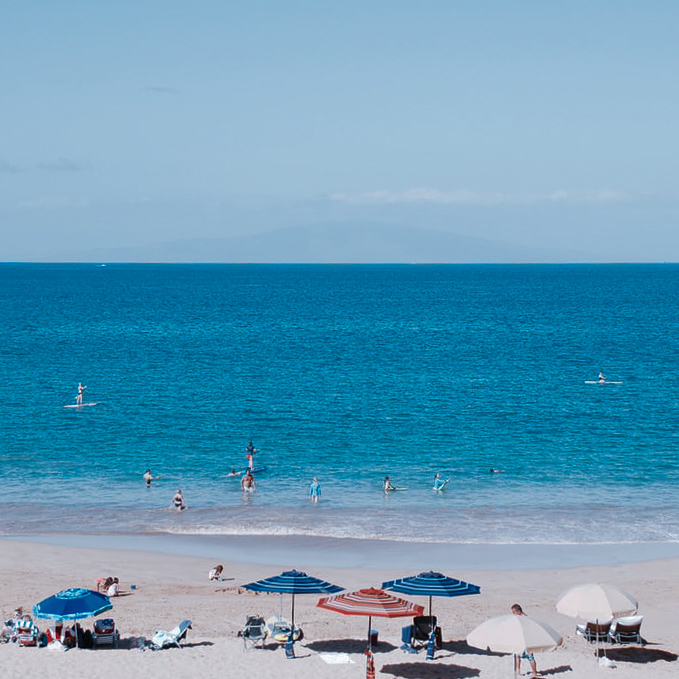 Beach with umbrellas and people in Hawaii