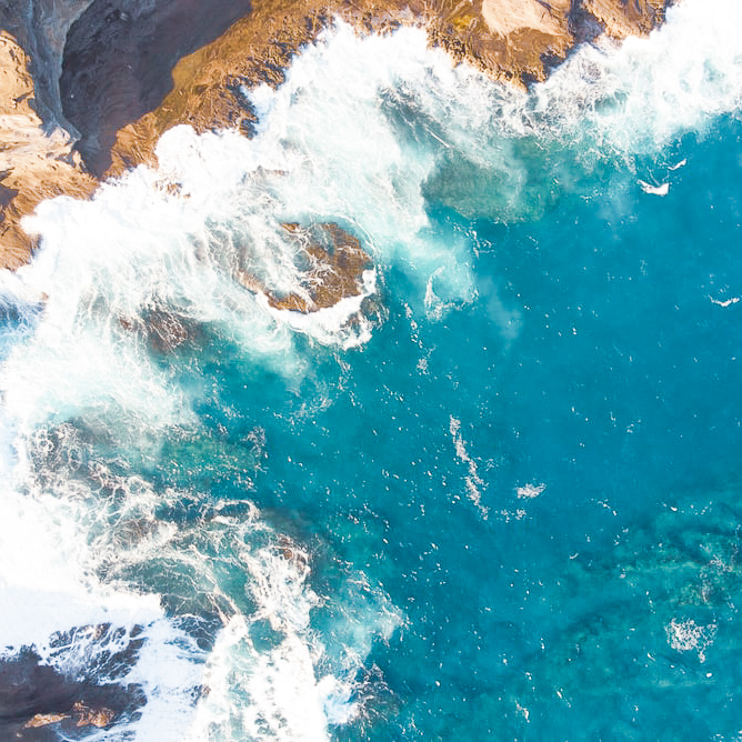 Birds eye view of waves crashing onto rocks