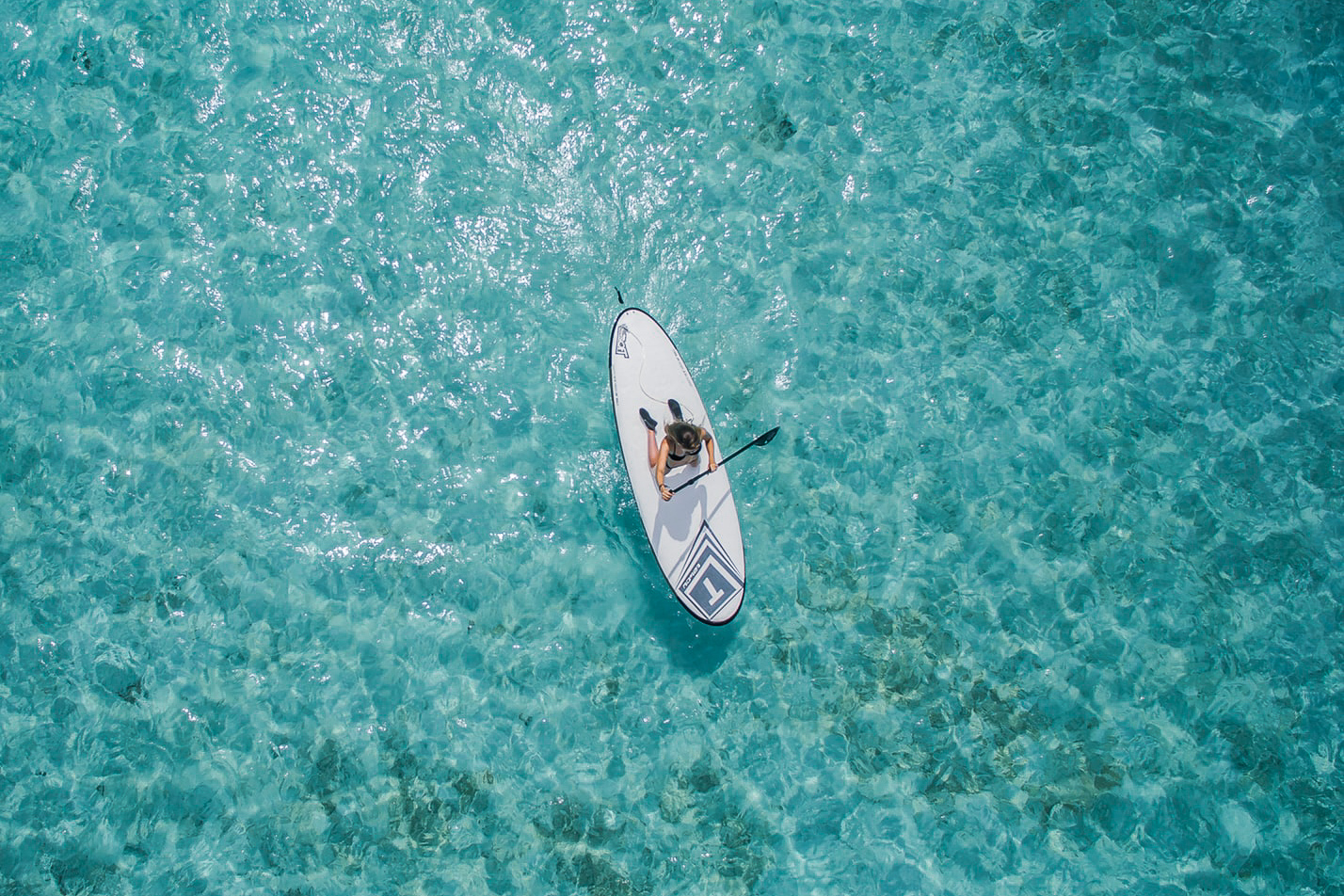 Birds-eye view of person on paddle board in ocean